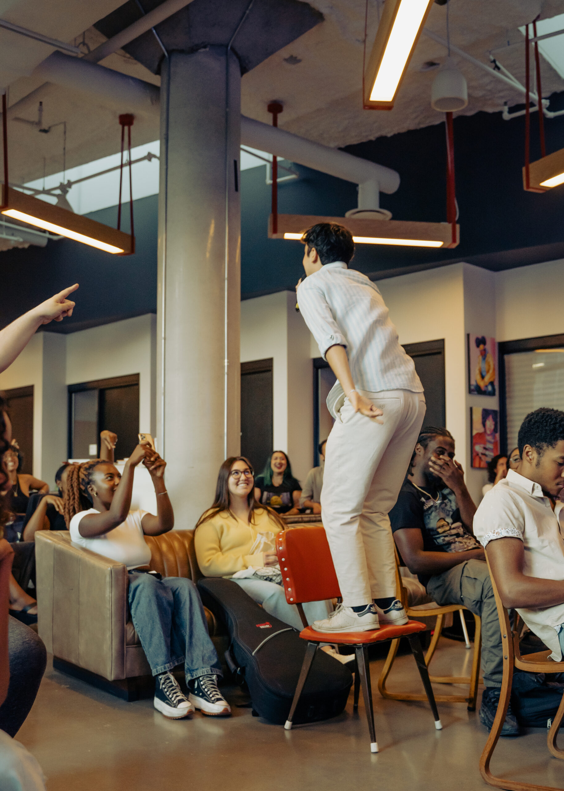Audience seated indoors, wearing masks, watching a presentation